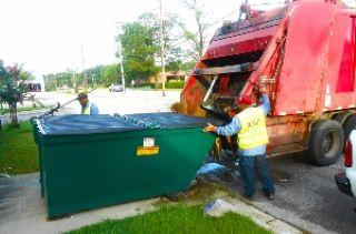 Man emptying dumpster into truck